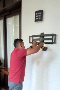 instalador de soportes colgando un soporte en la pered